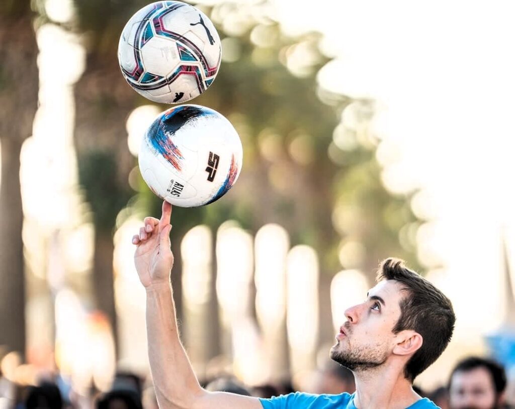 Jose Ferreras realizando trucos de freestyle fútbol en España con tres balones durante un evento deportivo