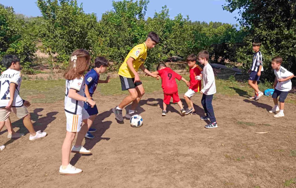 Niños participando en un reto de caños en una animación de fútbol
