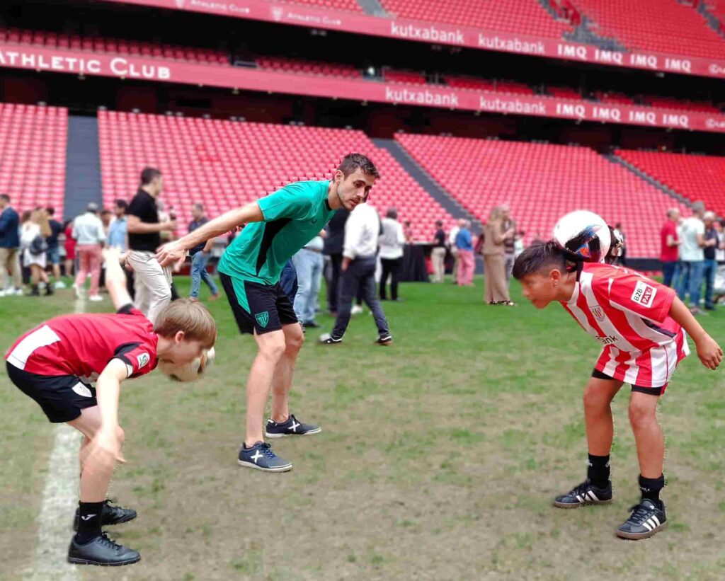Niños participando en un taller de trucos de fútbol durante una comunión.