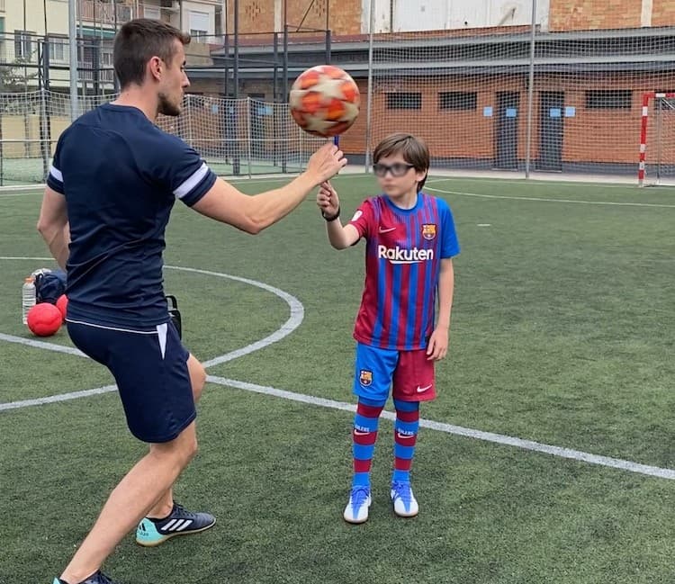 Show de fútbol freestyle en cumpleaños infantil en Barcelona con freestyler y cumpleañero realizando un truco con el balón